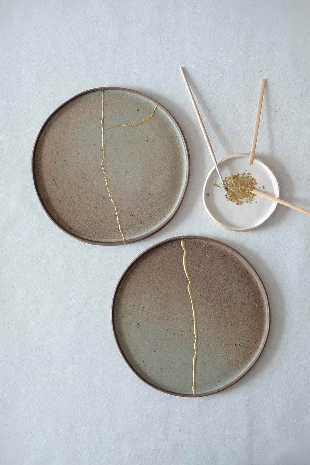 Două farfurii ceramice reparate cu aur prin tehnica japoneză Kintsugi